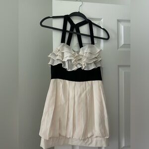 Cream and black BEBE dress with ruffles up top. Crosses in the back